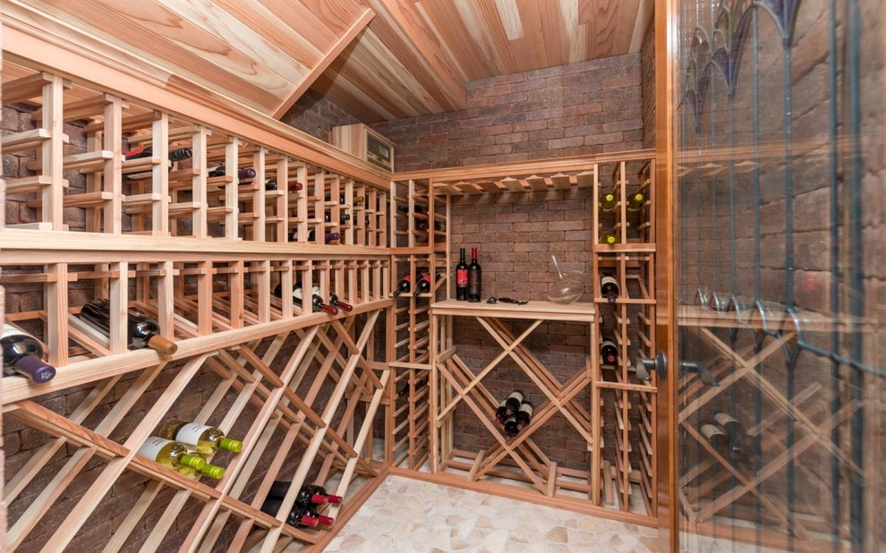 Cette photo montre une petite cave à vin chic avec un sol en travertin et des casiers losange.