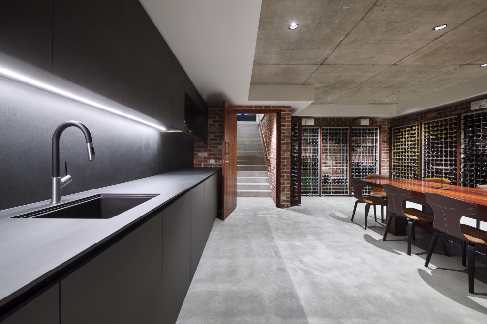Large modern wine cellar in Perth with concrete flooring, storage racks and grey floors.