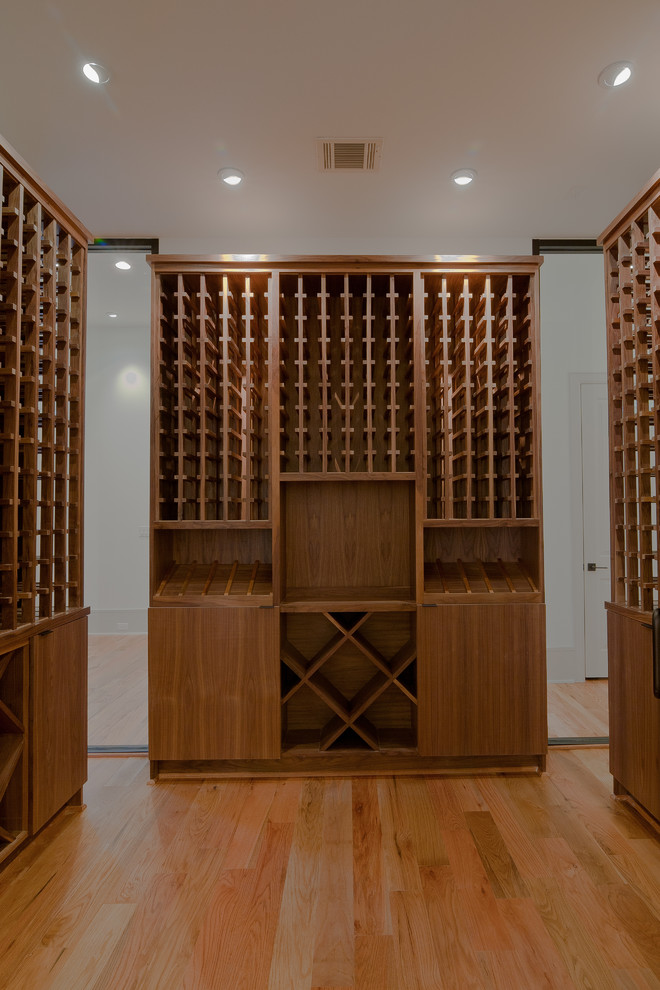 Exemple d'une cave à vin moderne de taille moyenne avec des casiers, un sol en bois brun et un sol marron.