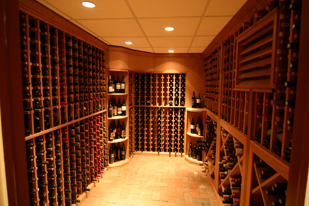 Cette image montre une cave à vin chalet de taille moyenne avec un sol en brique et des casiers.