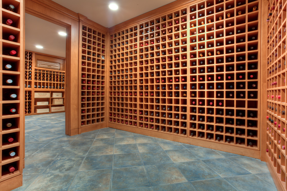 Cette photo montre une grande cave à vin tendance avec un sol en ardoise et des casiers.