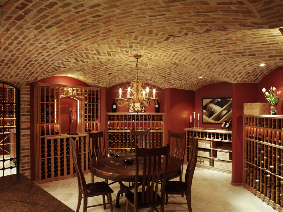 Bild på en mycket stor vintage vinkällare, med vinhyllor och beiget golv