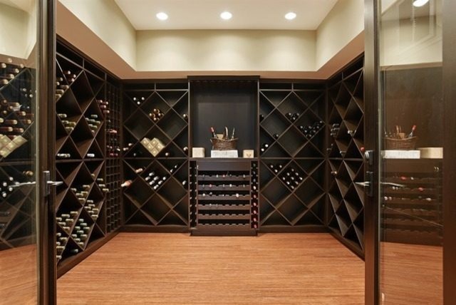 Idée de décoration pour une grande cave à vin design avec parquet en bambou et des casiers losange.