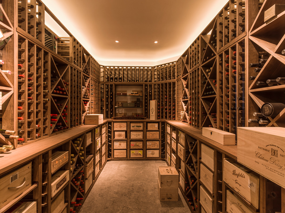 This is an example of a medium sized contemporary wine cellar in London with concrete flooring, cube storage and grey floors.