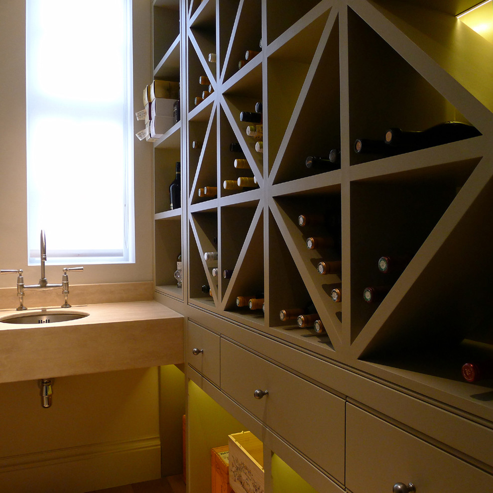 This is an example of a medium sized contemporary wine cellar in West Midlands with storage racks.