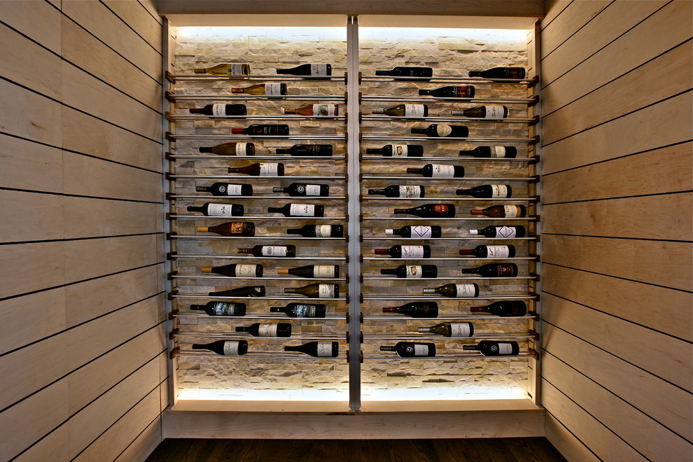 Cette photo montre une petite cave à vin tendance avec un sol en bois brun et un présentoir.