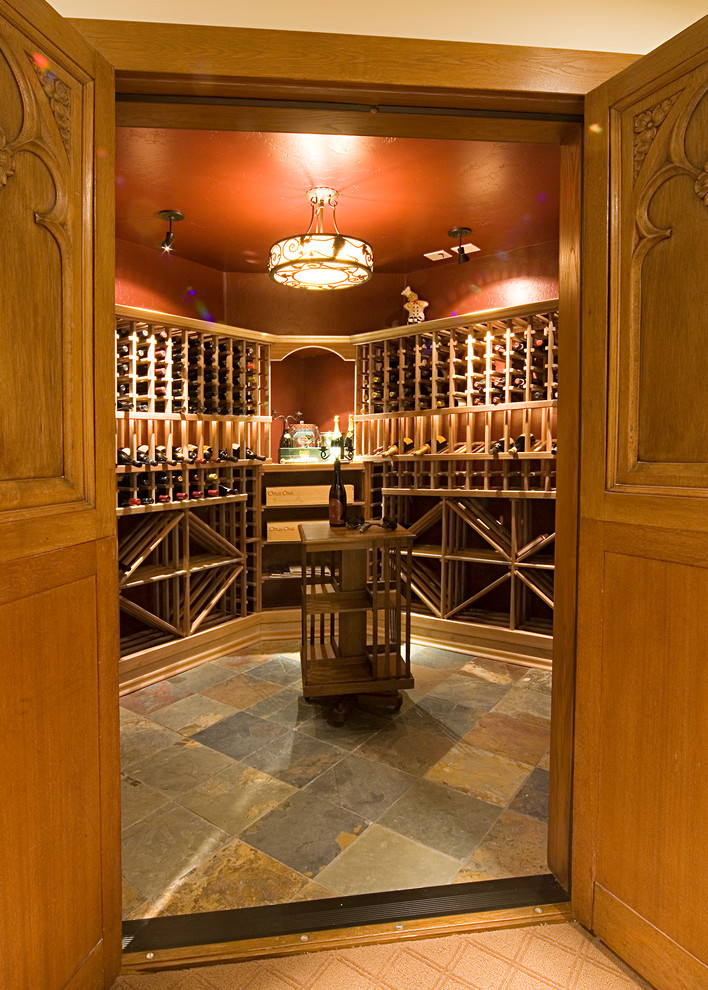 Foto på en stor vintage vinkällare, med vinhyllor och flerfärgat golv