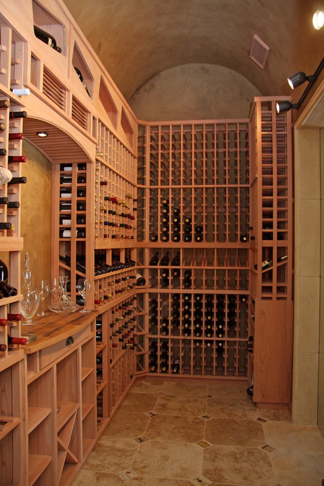 Large mid-century modern beige floor and travertine floor wine cellar photo in Sacramento with storage racks