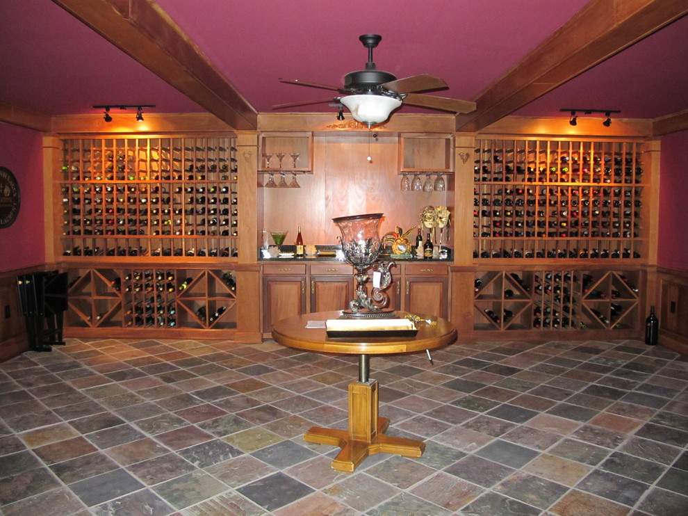 Bild på en mycket stor vintage vinkällare, med skiffergolv, vinhyllor och flerfärgat golv