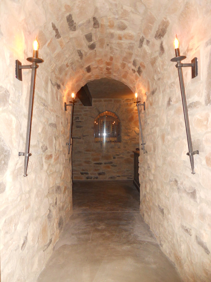 Exempel på en stor klassisk vinkällare, med betonggolv, vinhyllor och grått golv
