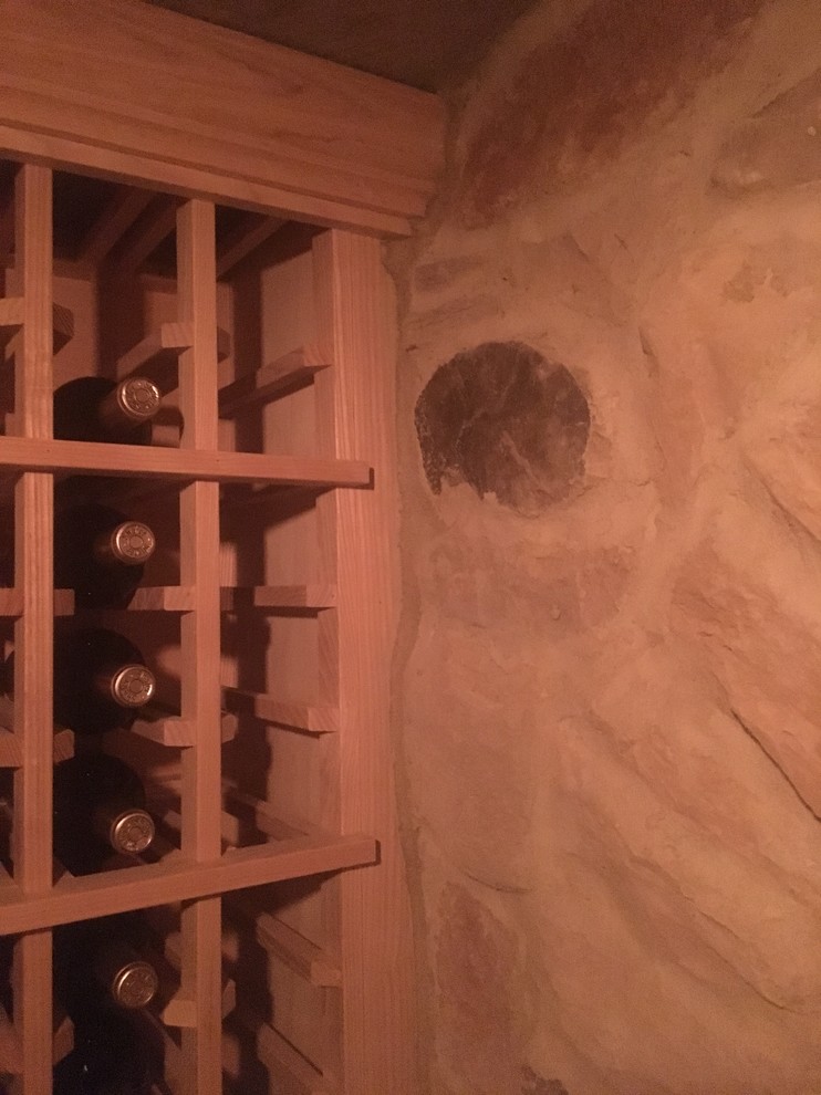 Idée de décoration pour une grande cave à vin tradition avec sol en béton ciré, des casiers et un sol gris.