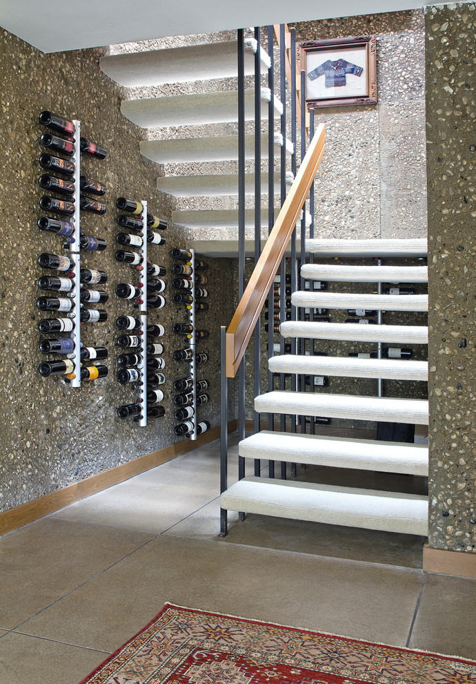 Inredning av en modern mellanstor vinkällare, med betonggolv, vinhyllor och grått golv