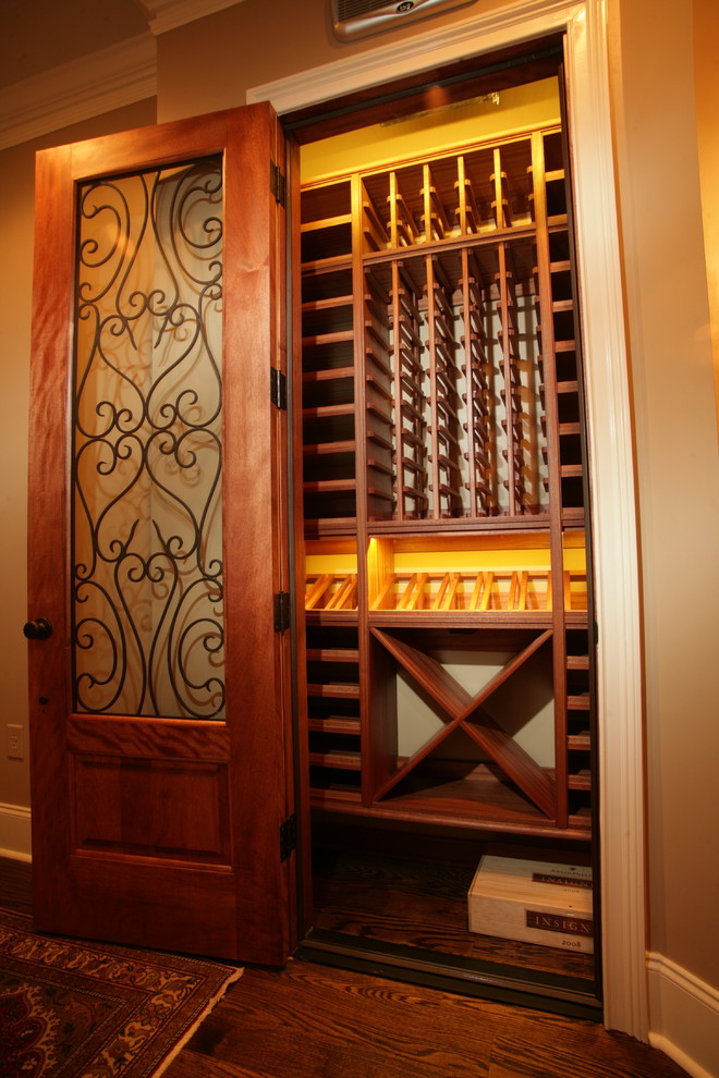 Aménagement d'une petite cave à vin classique avec un sol en bois brun, des casiers et un sol marron.