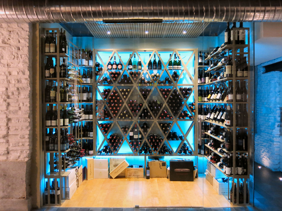 Wine cellar - large industrial light wood floor and brown floor wine cellar idea in Madrid with diamond bins