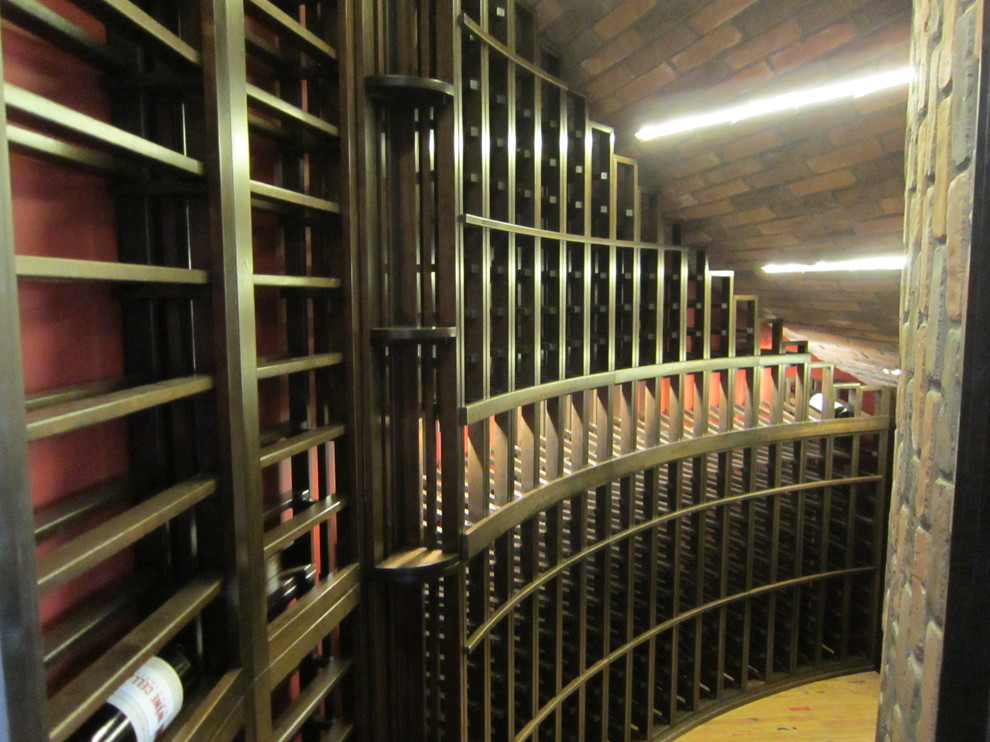Small traditional wine cellar in Dallas with light hardwood flooring, display racks and beige floors.