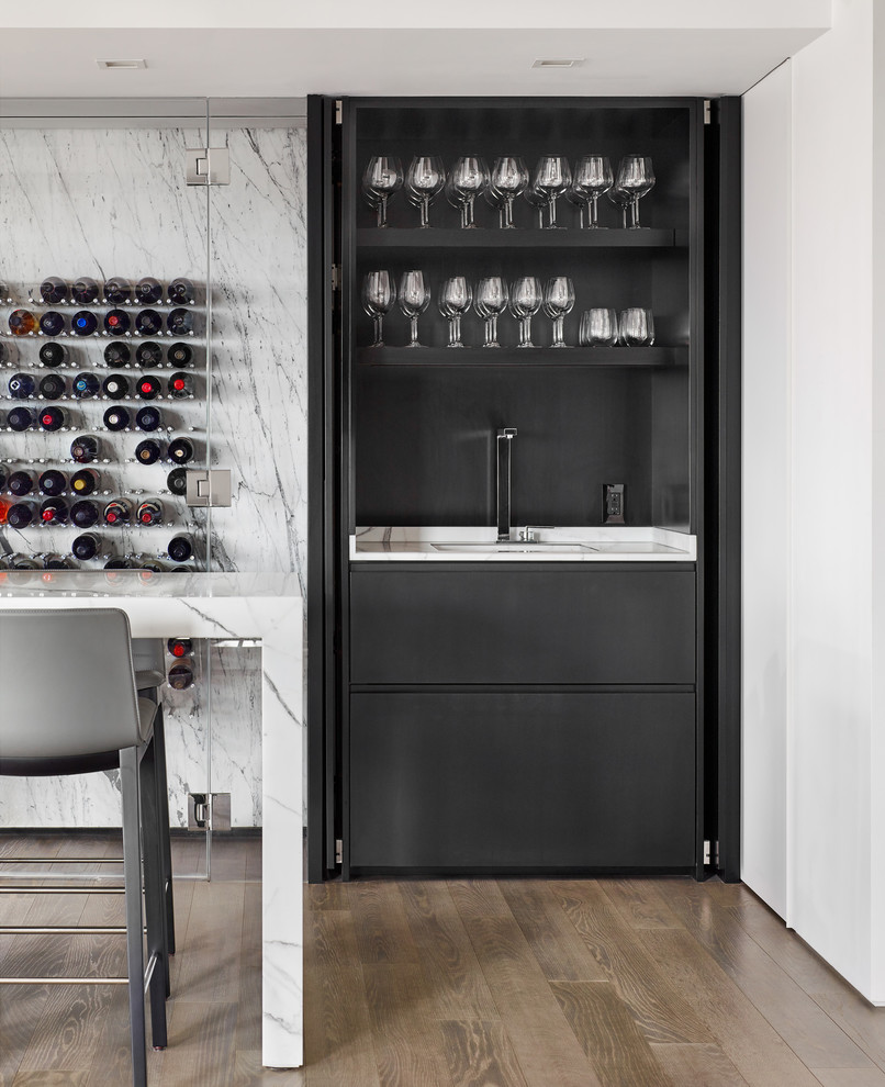 Wine cellar - mid-sized modern medium tone wood floor wine cellar idea in Boston with display racks