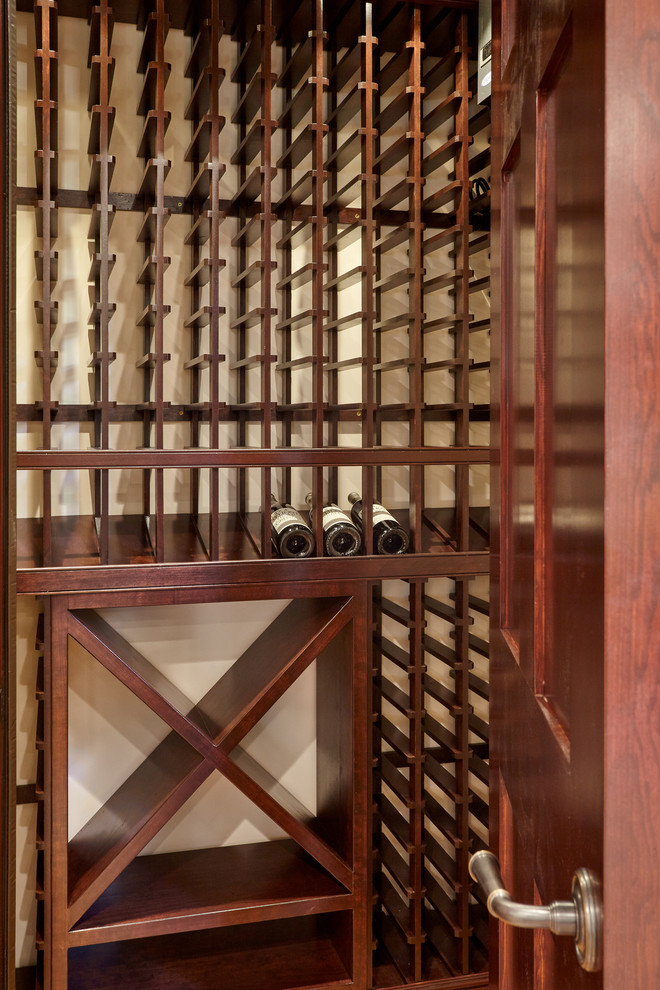 Cette image montre une petite cave à vin traditionnelle avec parquet clair et des casiers.