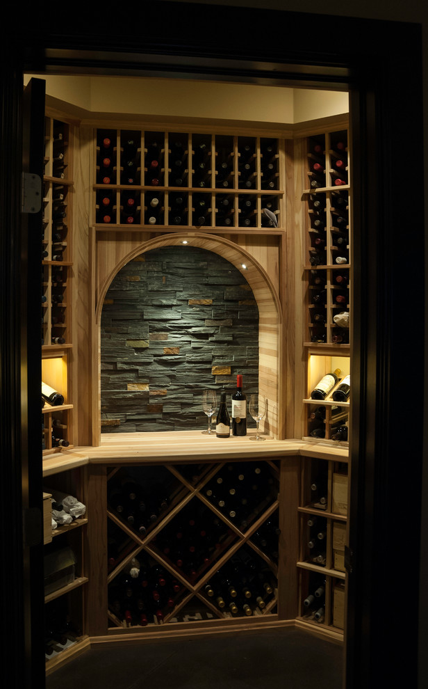 Idée de décoration pour une petite cave à vin minimaliste avec sol en béton ciré et des casiers.