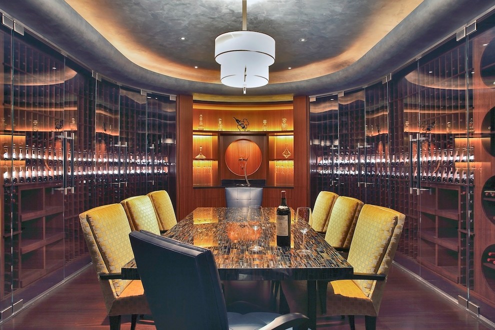 This is an example of an expansive contemporary wine cellar in New York with medium hardwood flooring and display racks.