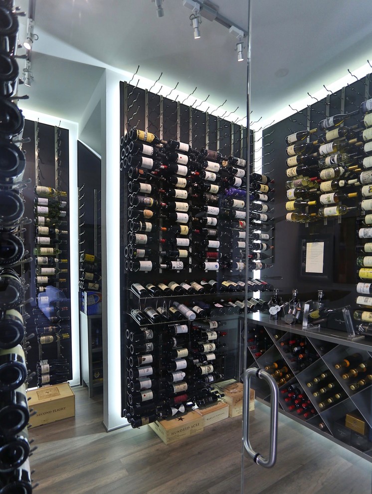Photo of a large contemporary wine cellar in Dallas with porcelain flooring, storage racks and grey floors.