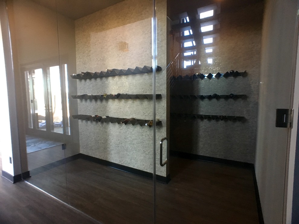 Bild på en stor funkis vinkällare, med vinhyllor, vinylgolv och grått golv