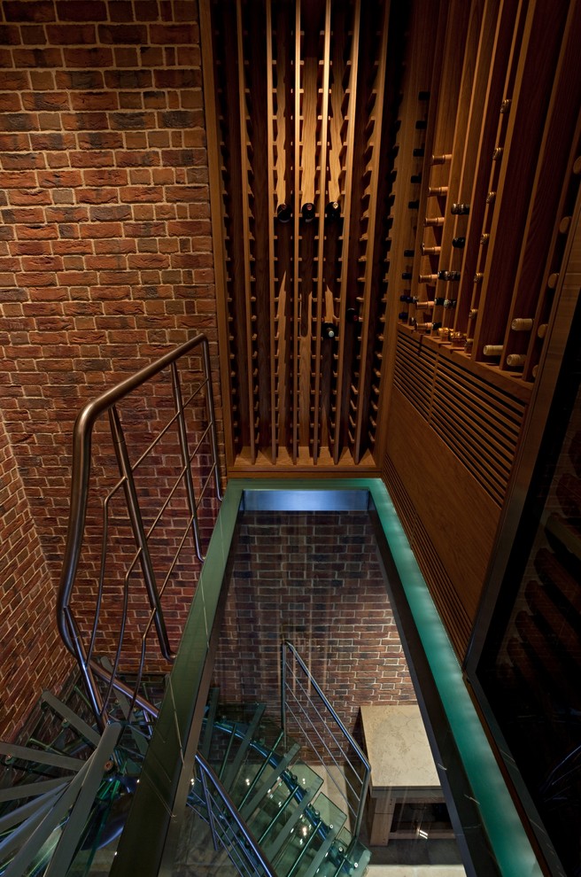 Design ideas for a contemporary wine cellar in London with storage racks.