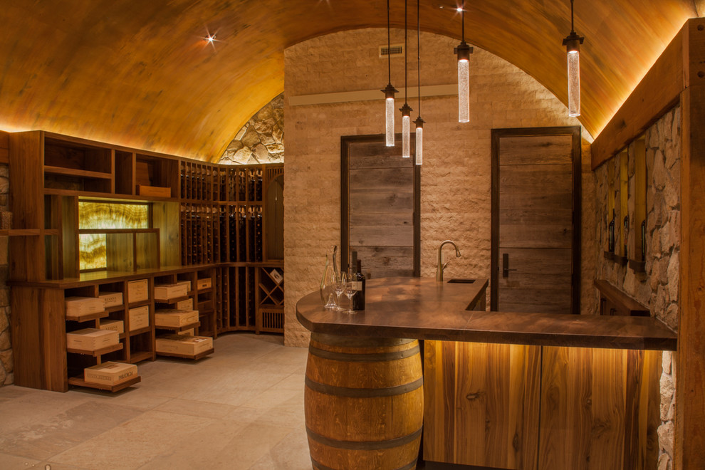 Mid-sized trendy travertine floor and beige floor wine cellar photo in Denver with storage racks