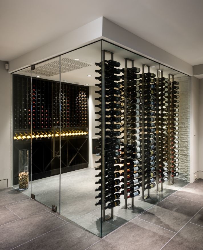 Foto på en stor funkis vinkällare, med klinkergolv i porslin, vindisplay och grått golv
