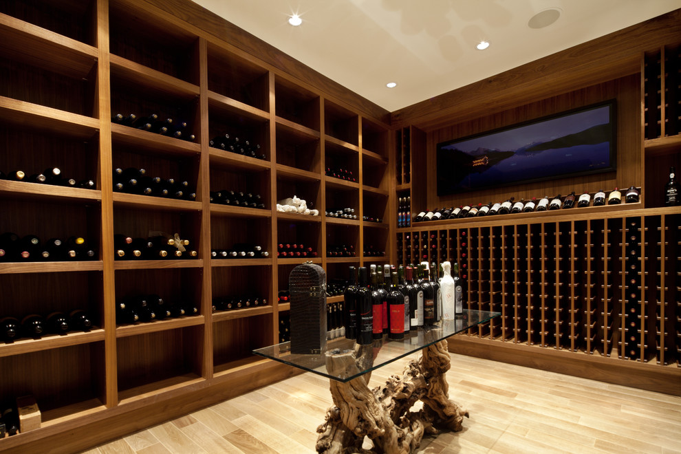 Aménagement d'une cave à vin contemporaine avec parquet clair, des casiers et un sol beige.