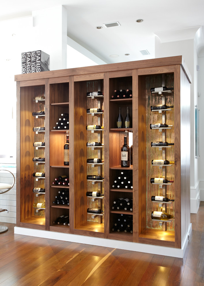 This is an example of a contemporary wine cellar in Miami with medium hardwood flooring and display racks.
