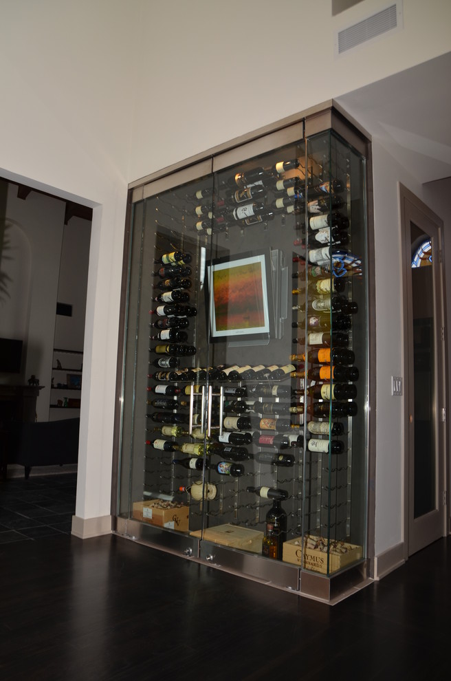 Cette photo montre une cave à vin tendance de taille moyenne avec parquet foncé et un présentoir.