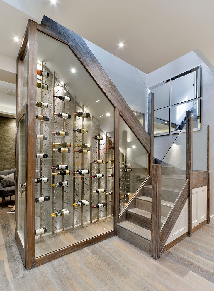 Photo of a contemporary wine cellar in London with light hardwood flooring, storage racks and brown floors.