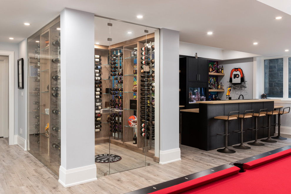 Medium sized contemporary wine cellar in Toronto with light hardwood flooring, storage racks and brown floors.