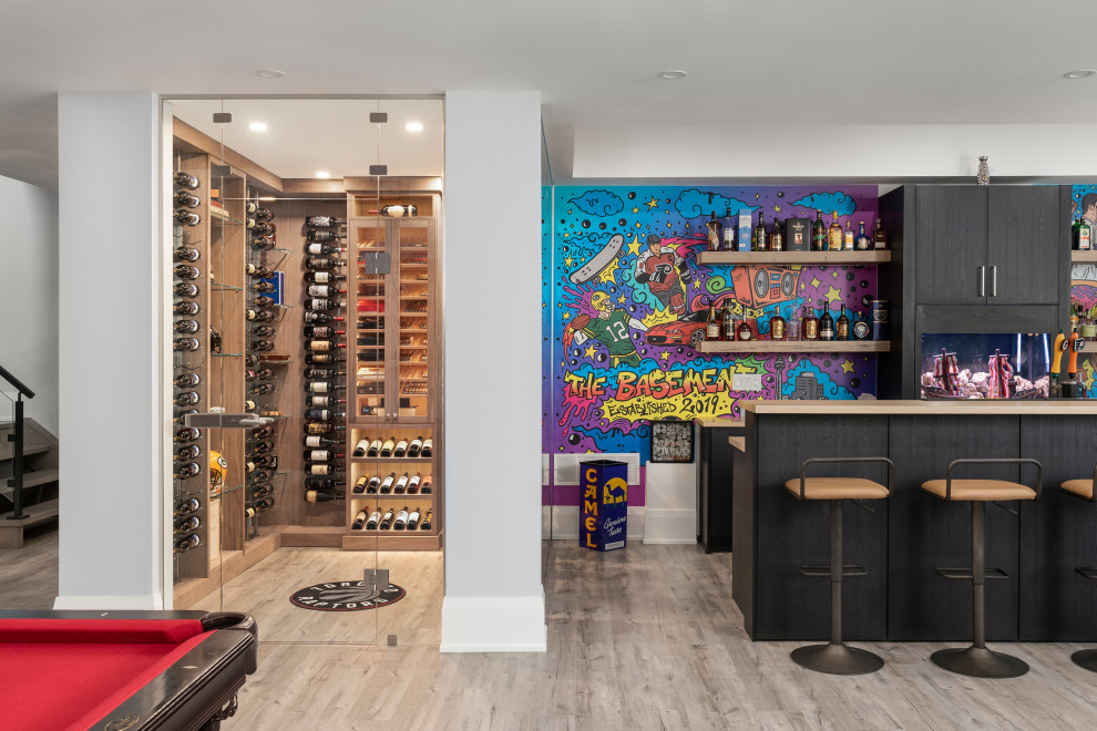 Mittelgroßer Moderner Weinkeller mit hellem Holzboden, waagerechter Lagerung und braunem Boden in Toronto