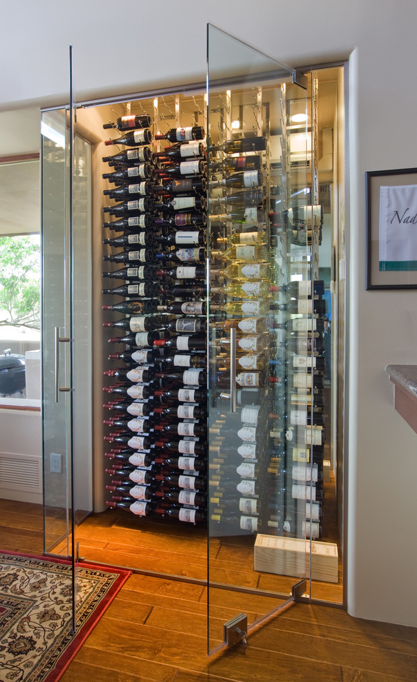 Design ideas for a small contemporary wine cellar in Phoenix with medium hardwood flooring, storage racks and brown floors.