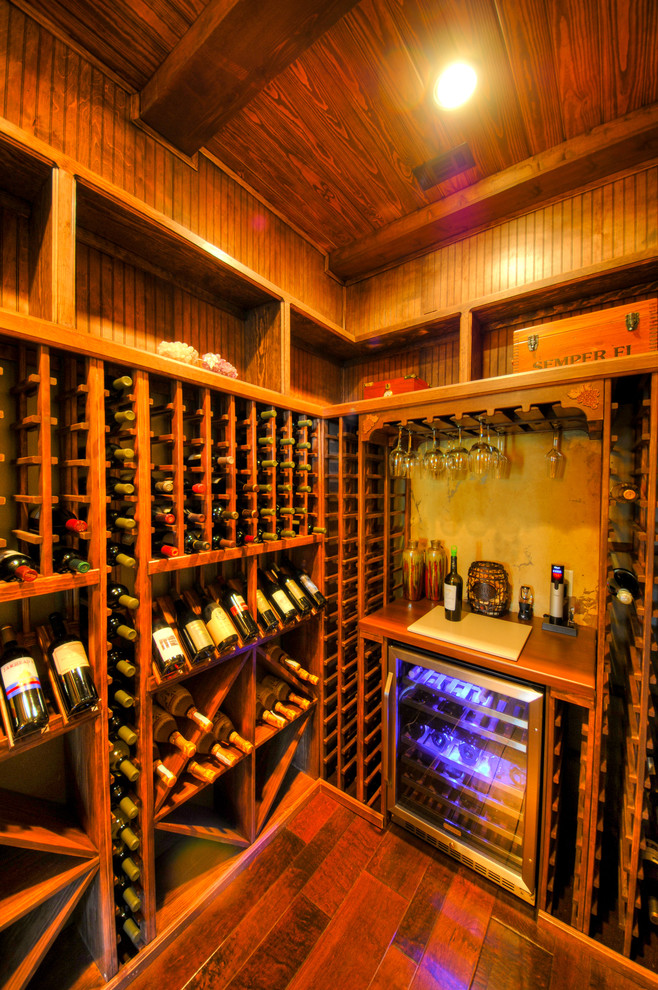 Photo of a medium sized rustic wine cellar in Austin with medium hardwood flooring and display racks.