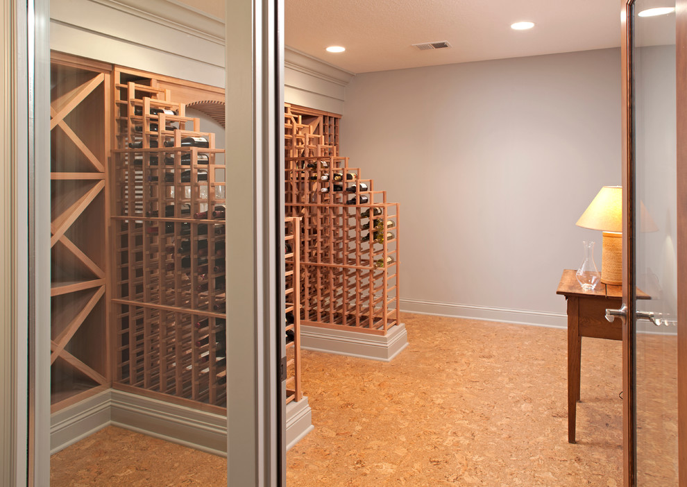 Large traditional wine cellar in Minneapolis with cork flooring and storage racks.