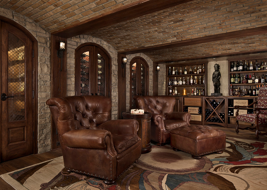 Large traditional wine cellar in Detroit with dark hardwood flooring, display racks and brown floors.