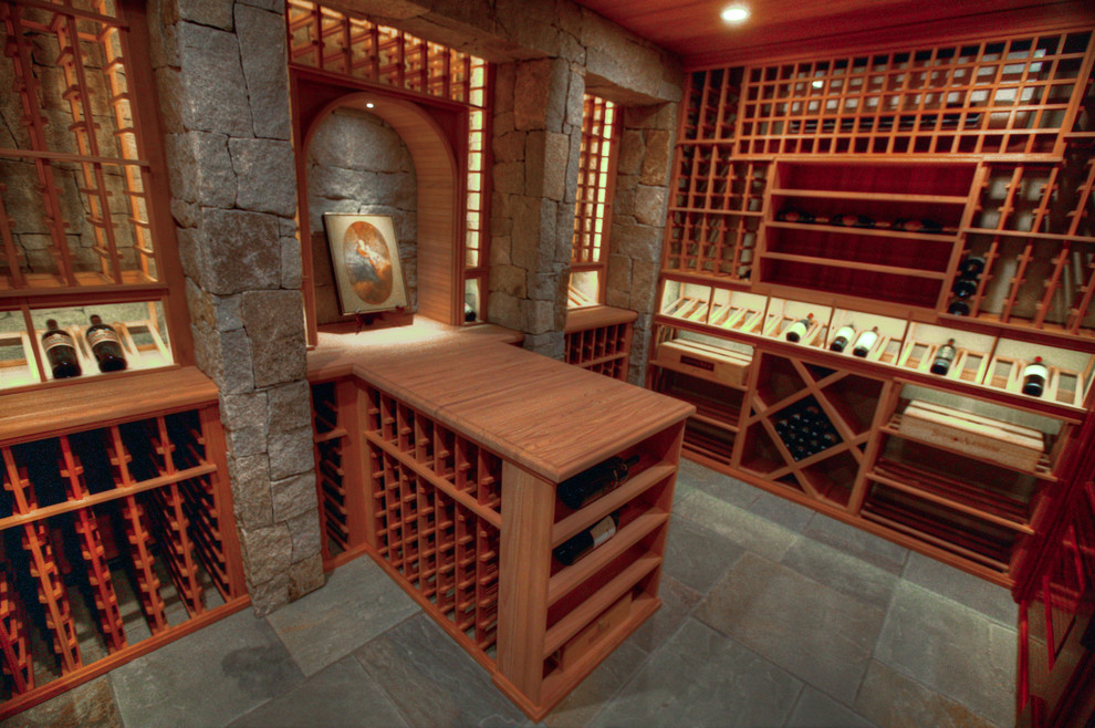 Cette photo montre une grande cave à vin montagne avec un sol en ardoise et des casiers.