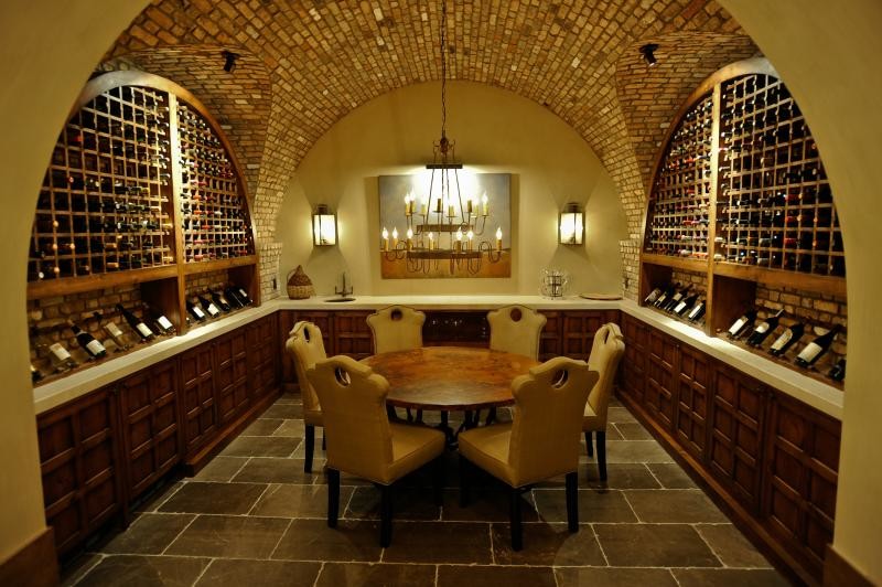 Bild på en stor medelhavsstil vinkällare, med skiffergolv, vinhyllor och grått golv