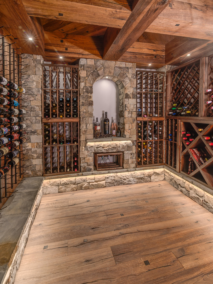 This is an example of a rustic wine cellar in Other with light hardwood flooring and storage racks.