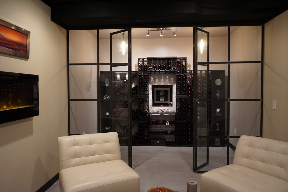 Cette photo montre une grande cave à vin éclectique avec sol en béton ciré et un présentoir.