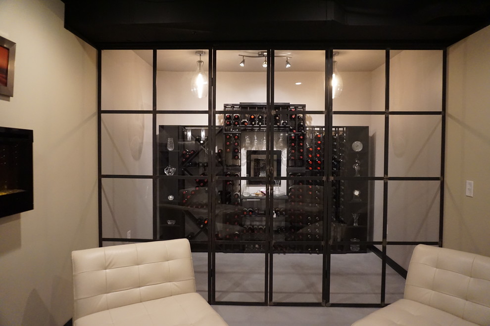 Example of a large eclectic concrete floor wine cellar design in Columbus with display racks