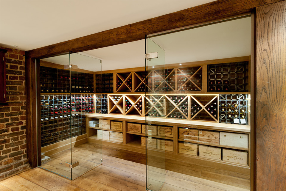 Idée de décoration pour une grande cave à vin craftsman avec parquet clair et des casiers.