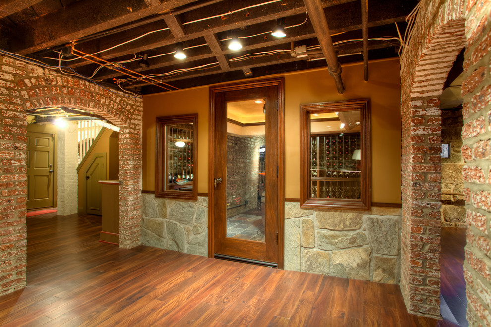 Wine cellar - mid-sized eclectic medium tone wood floor wine cellar idea in New York with storage racks