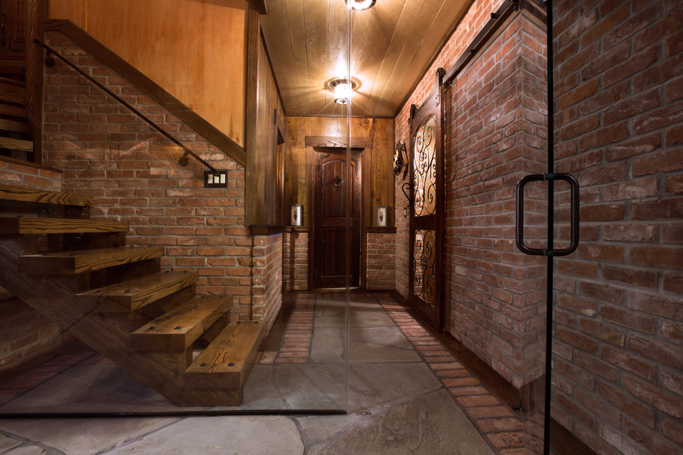 Wine cellar - large rustic gray floor and slate floor wine cellar idea in New York with storage racks