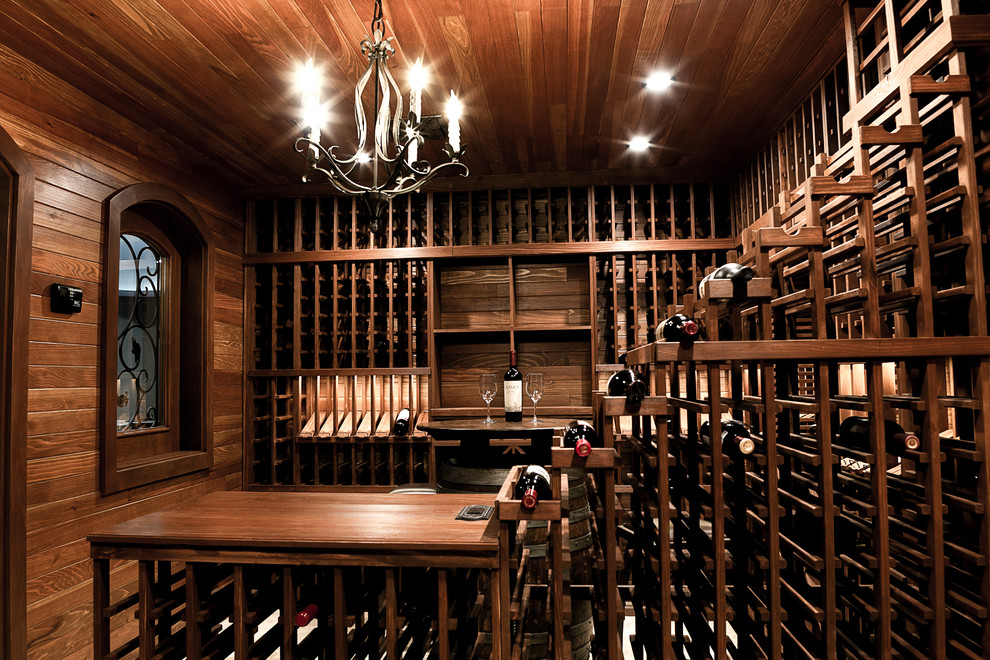 Exemple d'une grande cave à vin chic avec un sol en travertin et des casiers.
