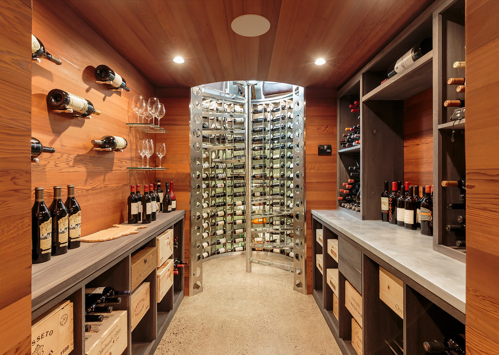 This is an example of a medium sized contemporary wine cellar in New York with concrete flooring, display racks and grey floors.