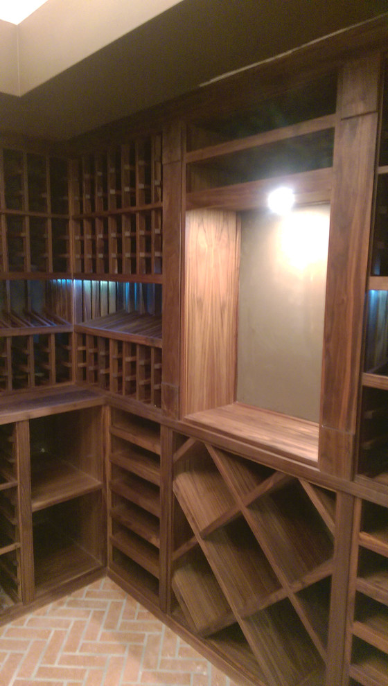 Exemple d'une cave à vin chic de taille moyenne avec des casiers et un sol en bois brun.