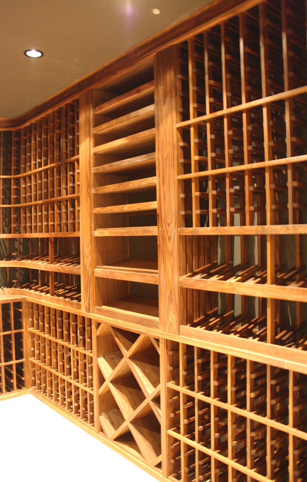 Aménagement d'une cave à vin classique de taille moyenne avec un sol en bois brun et des casiers.